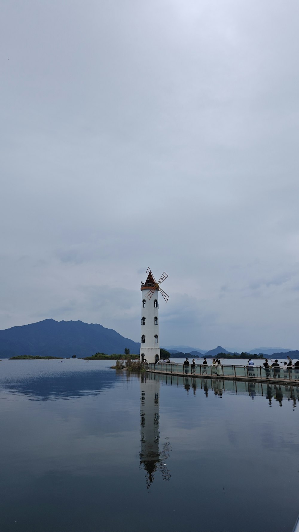 a white tower sitting in the middle of a lake