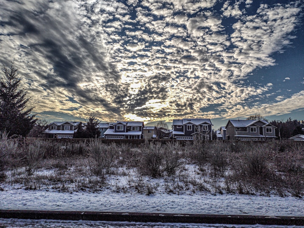 a group of houses sitting on top of a snow covered field