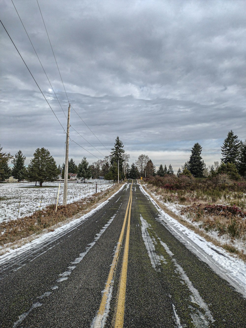 an empty road with snow on the ground