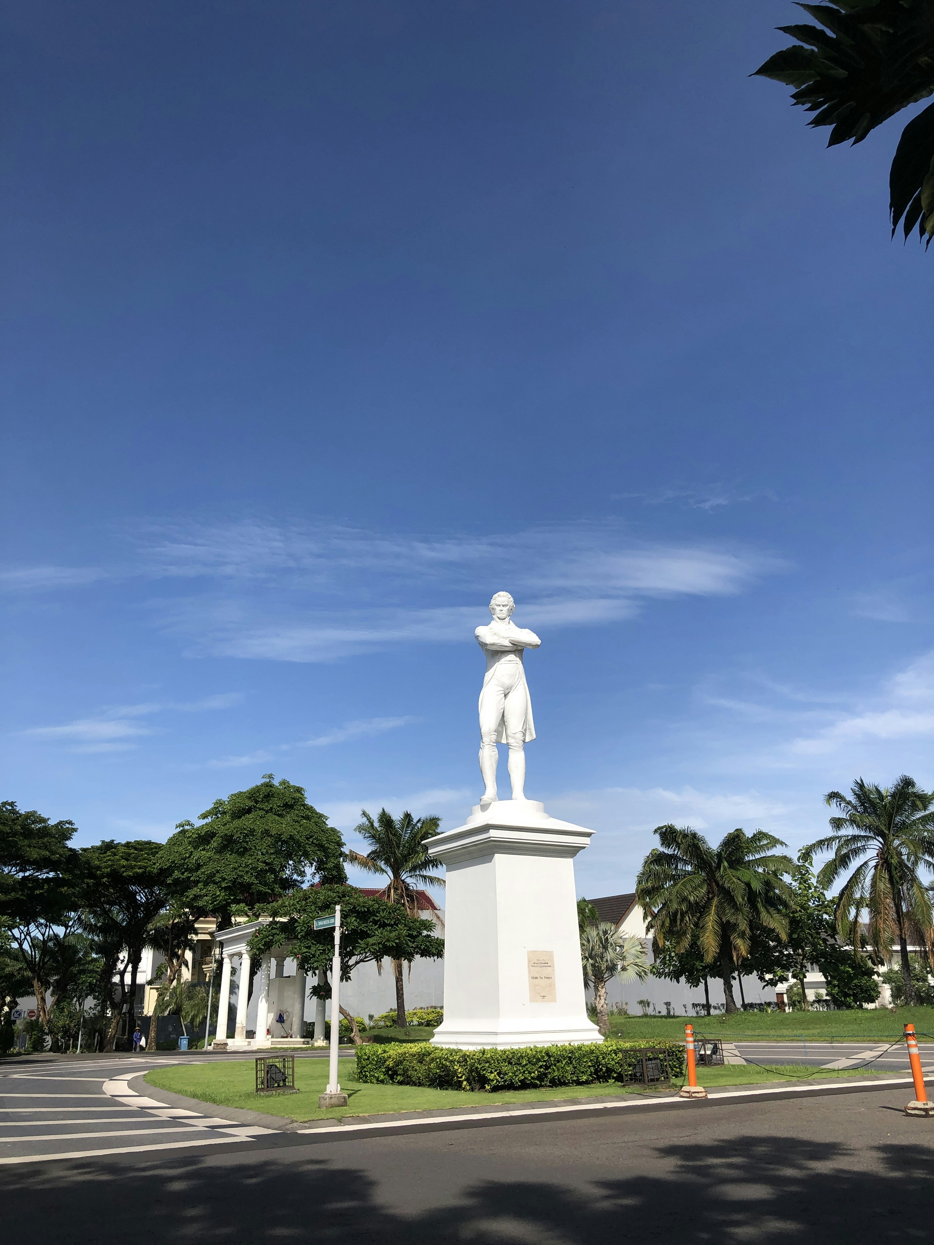 a statue of a man standing in the middle of a street