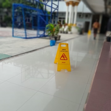 a yellow caution sign sitting on top of a white floor