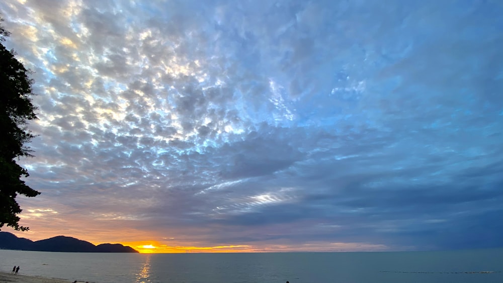 a person walking on a beach at sunset