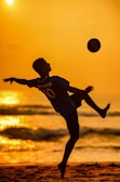a man is playing with a ball on the beach
