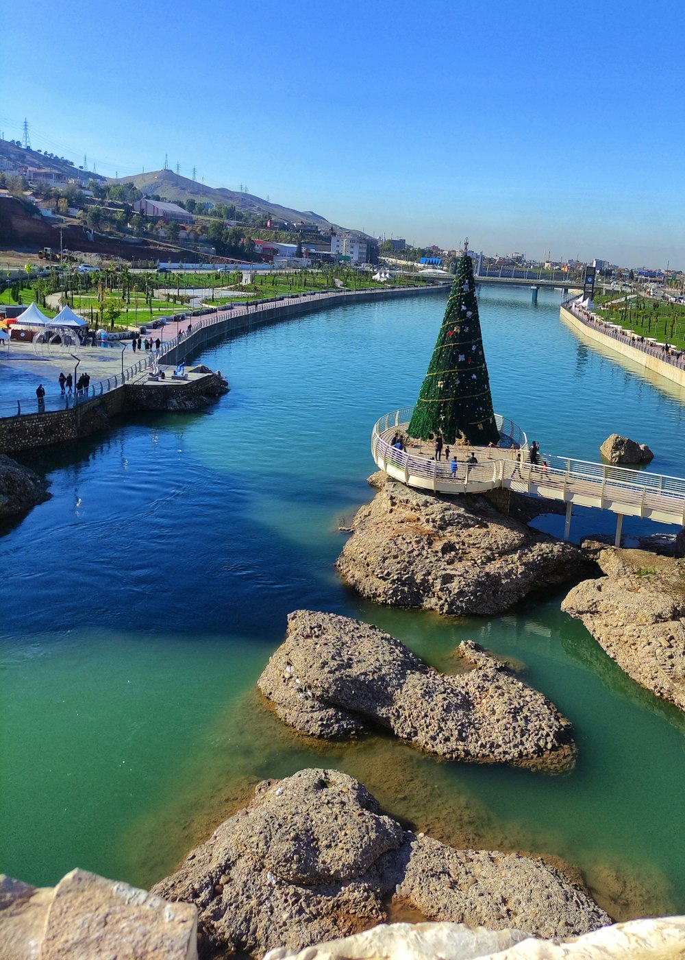 a river with a christmas tree in the middle of it
