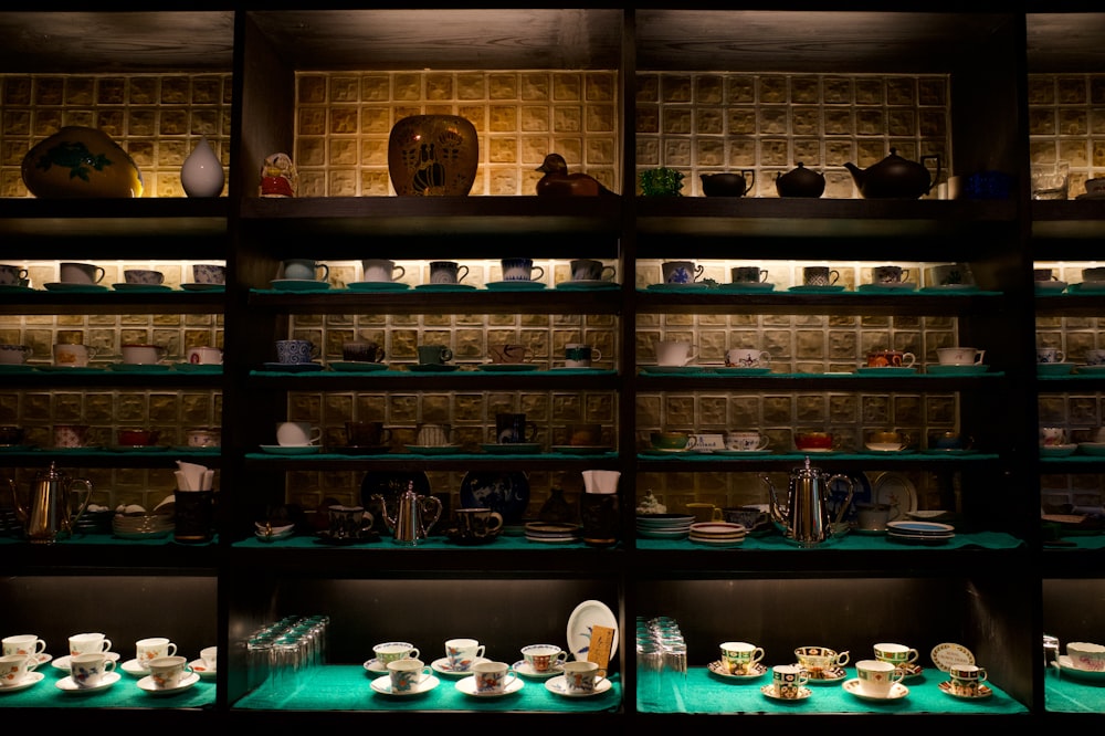 a shelf filled with lots of tea cups and saucers