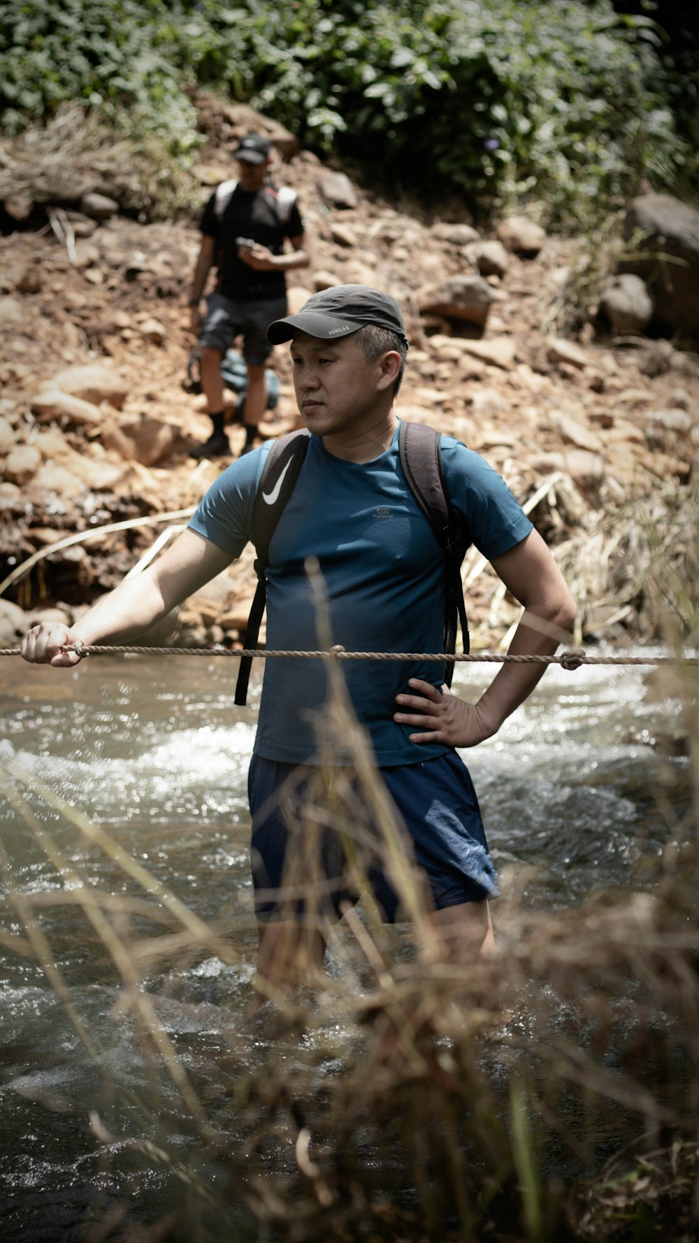 a man crossing a river with a backpack