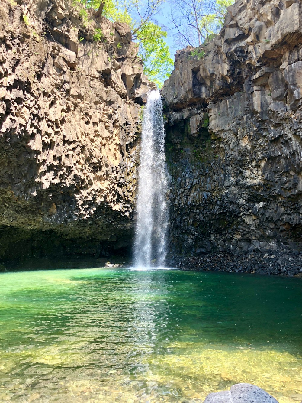 水域の真ん中に滝が見えます