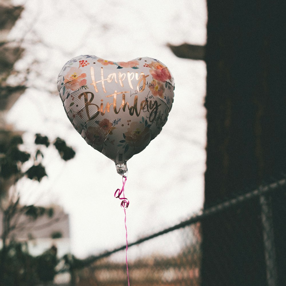 a heart shaped balloon that says happy birthday