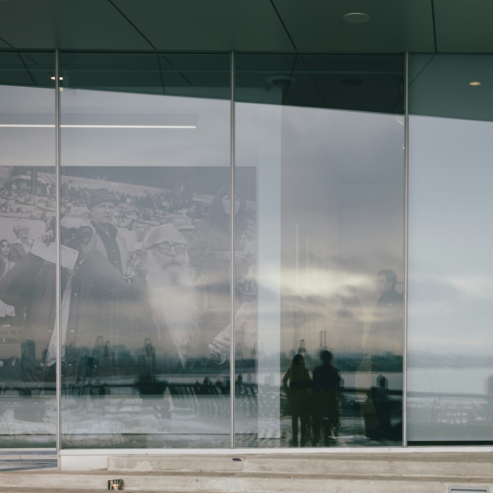 two people standing in front of a large window