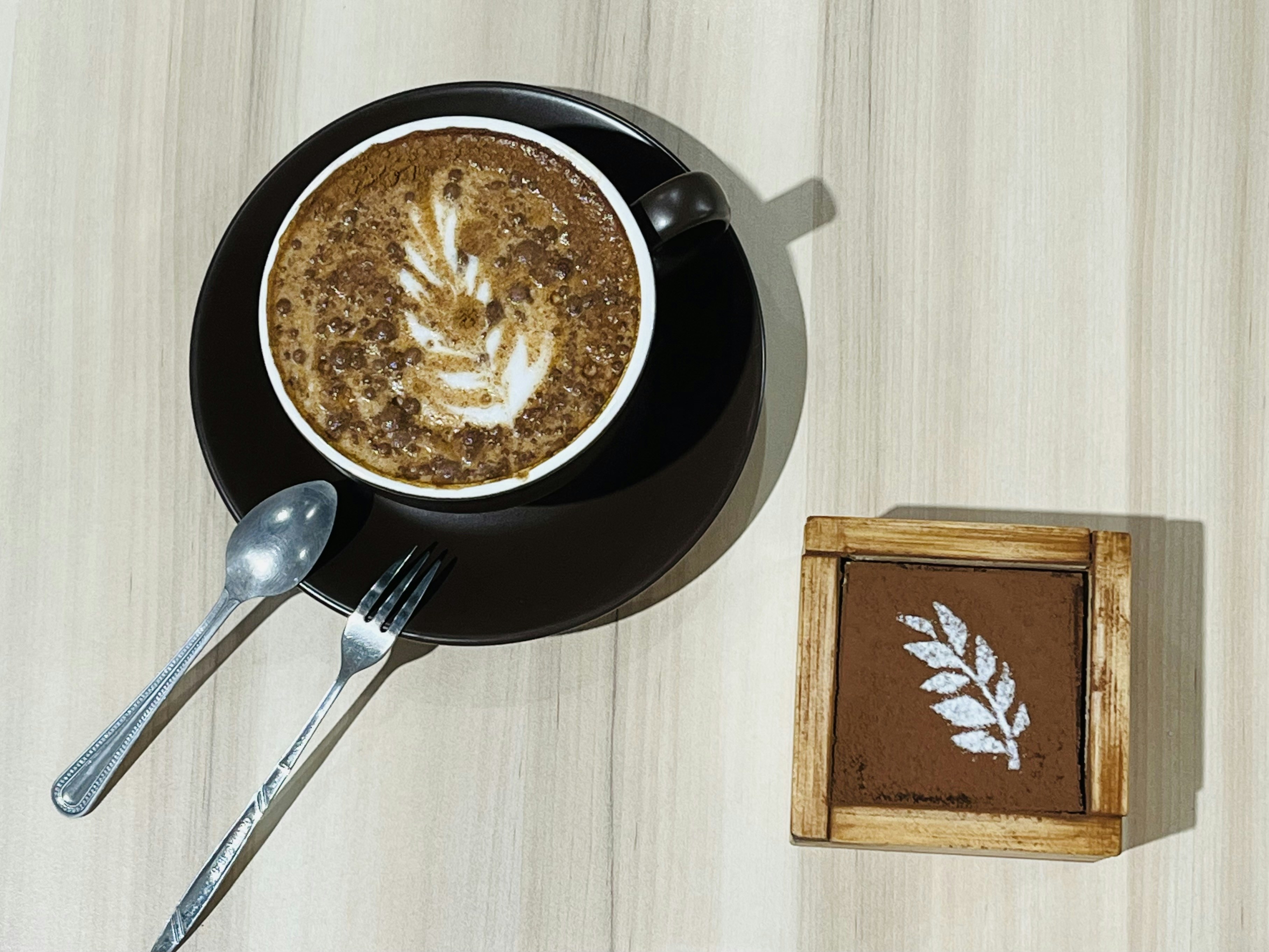 Velvet Sip latte with intricate leaf latte art in a wide ceramic cup, warm lighting