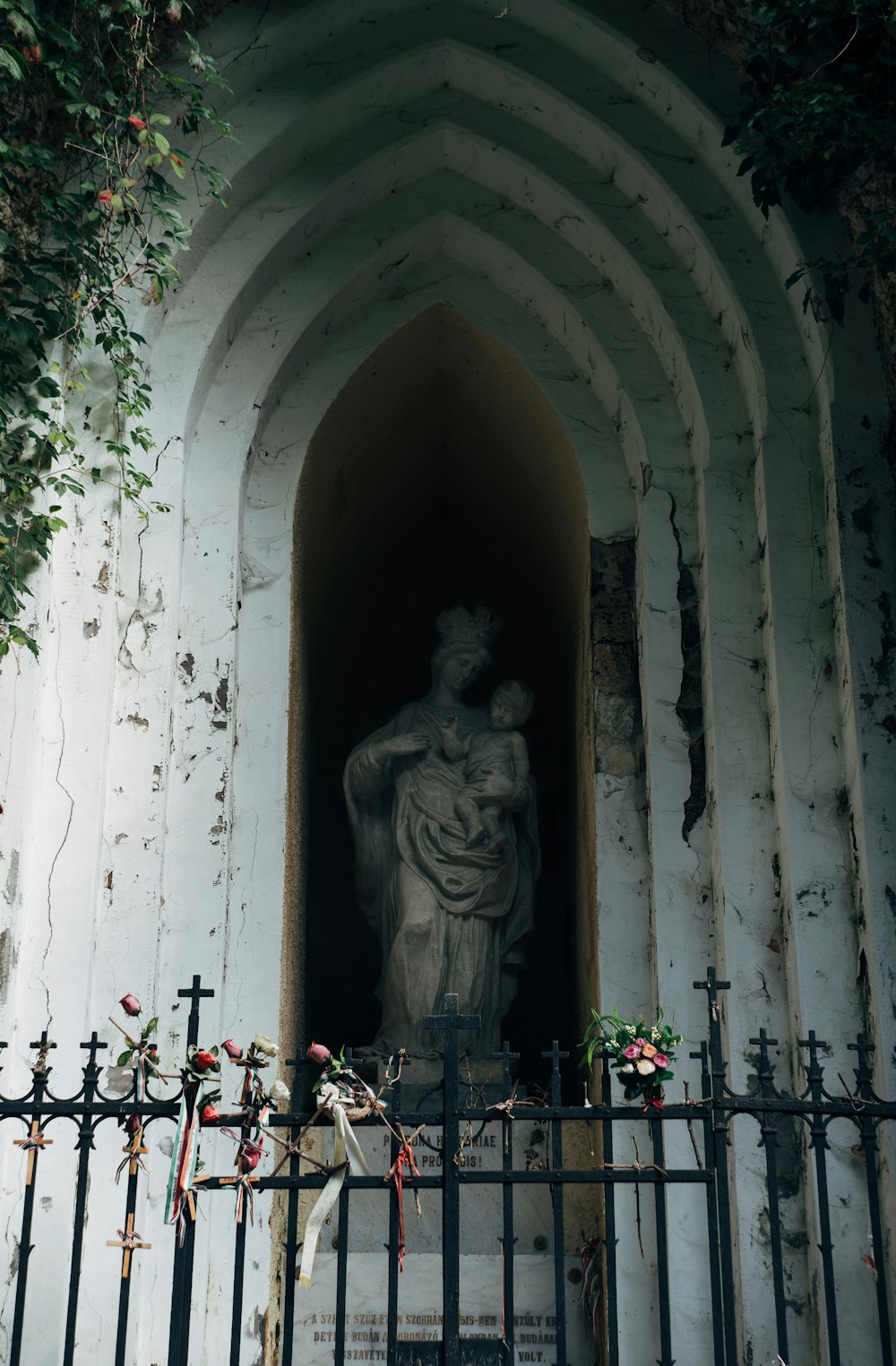 a statue of a woman holding a child in a doorway