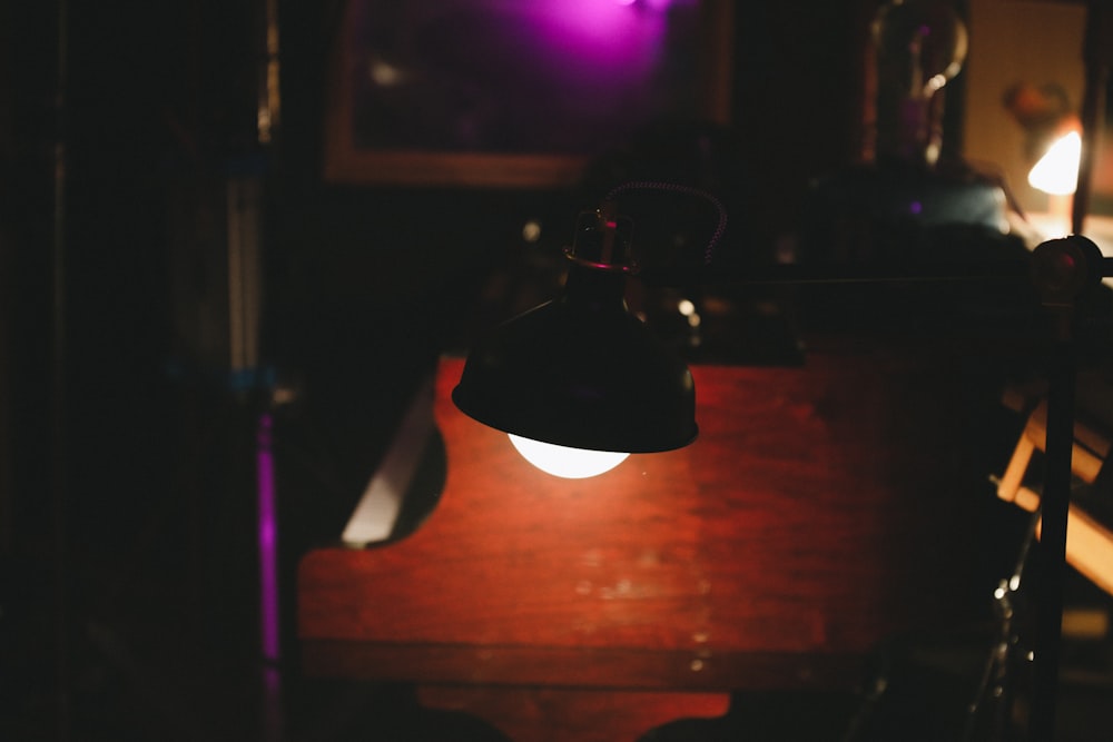 a dark room with a table and a lamp