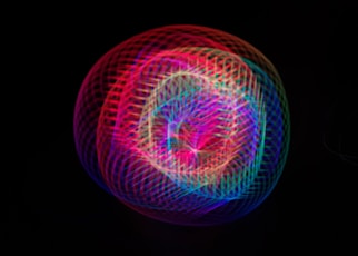 a colorful ball of light on a black background