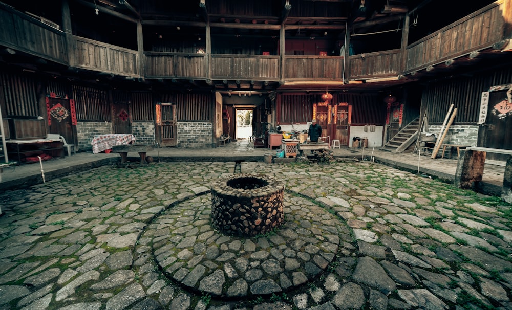 a stone courtyard with a fire pit in the middle