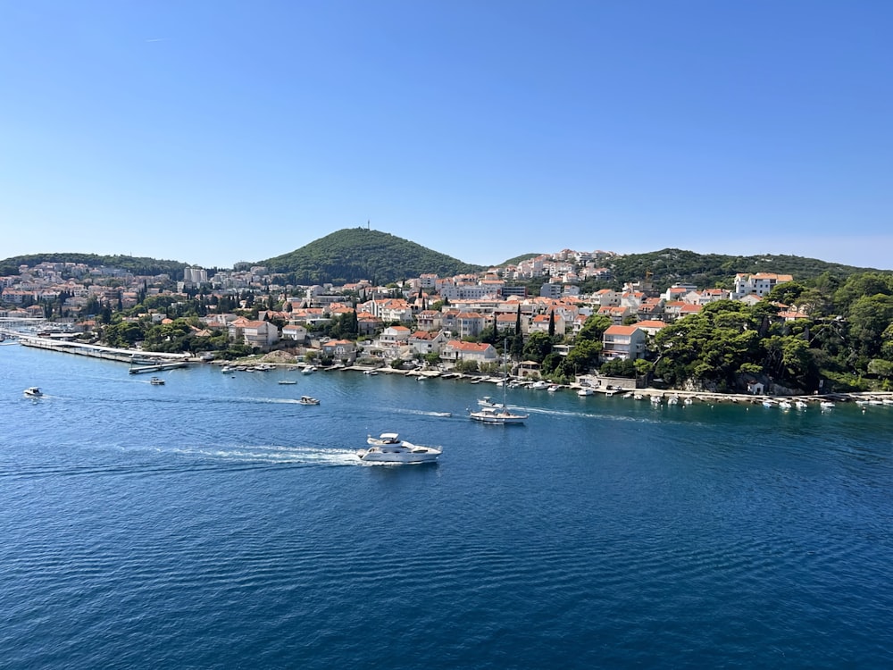 a boat traveling on a body of water near a city