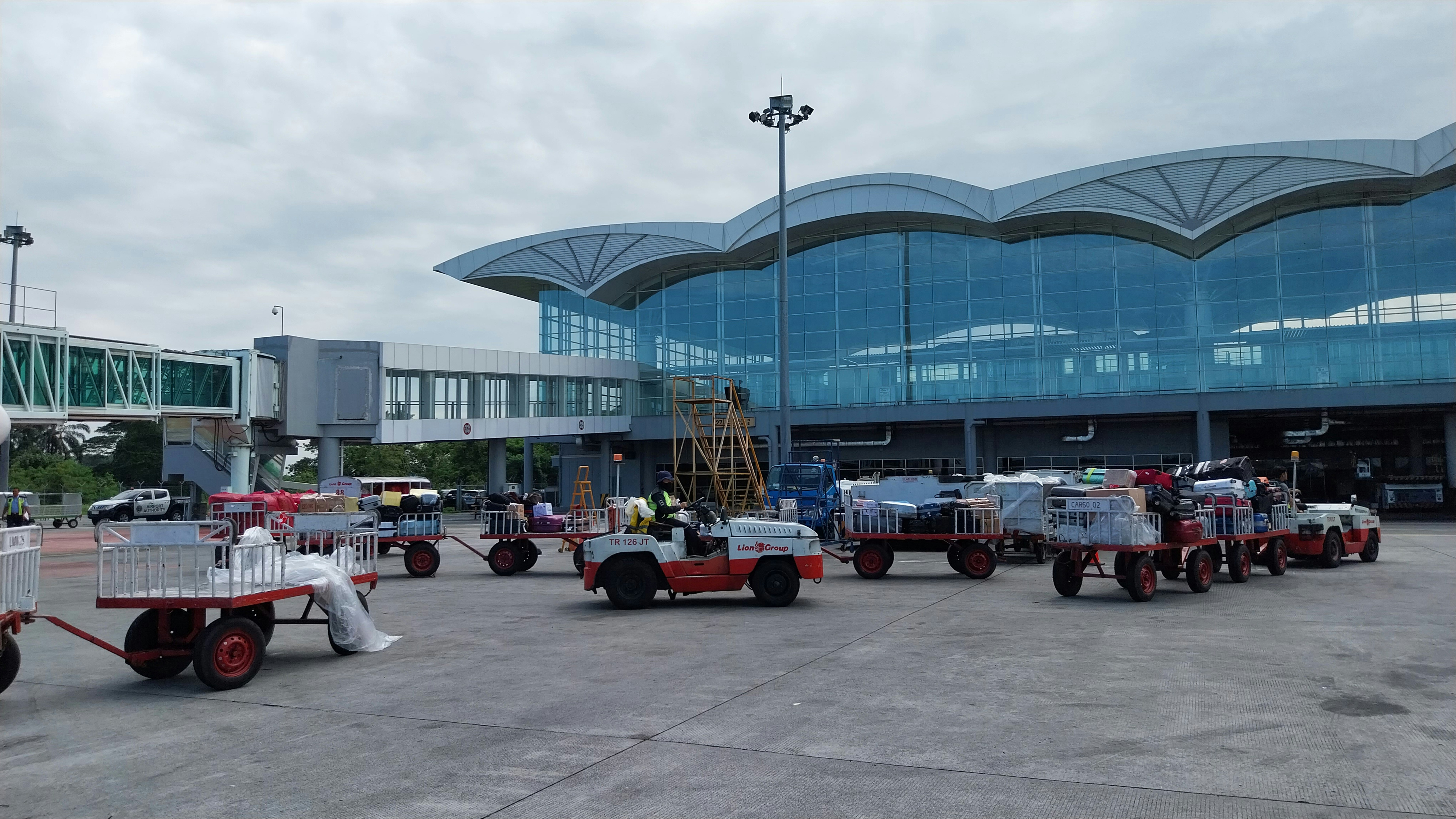 a group of trucks parked in front of an airport, 
