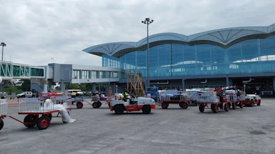 a group of trucks parked in front of an airport