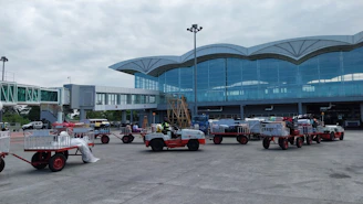 a group of trucks parked in front of an airport