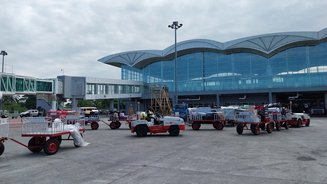 a group of trucks parked in front of an airport,
