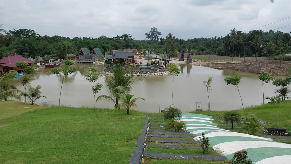 un grande specchio d'acqua seduto accanto a un campo verde lussureggiante