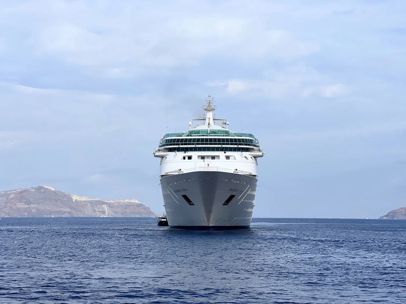 A cruise ship sailing across calm blue sea