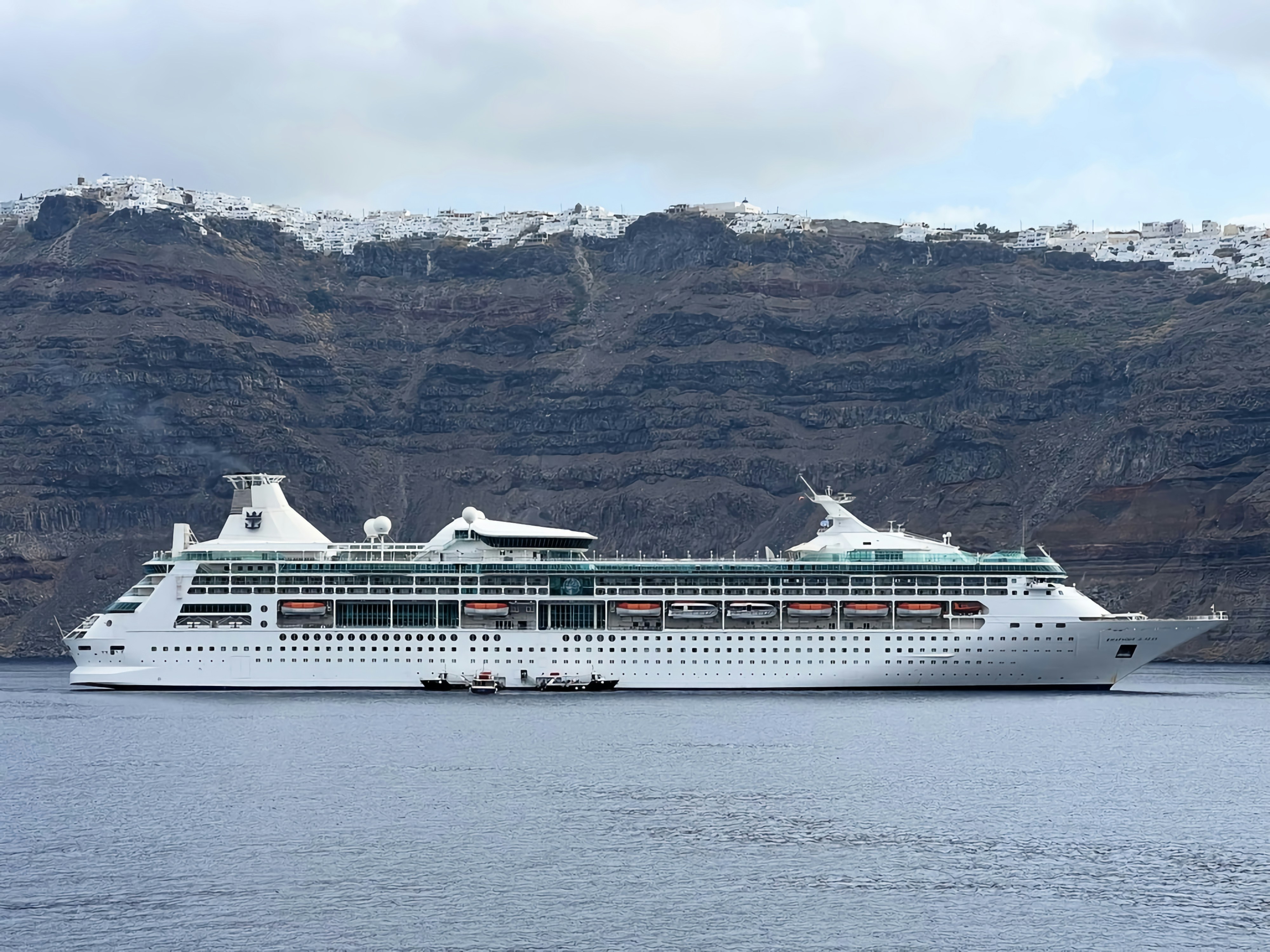 a cruise ship in the water with mountains in the background, 