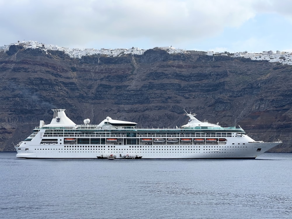 a cruise ship in the water with mountains in the background