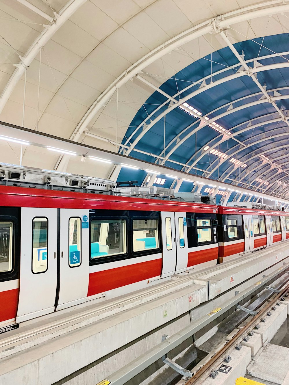 a red and white train traveling through a train station