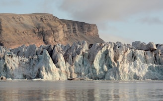 a large glacier with a mountain in the background
