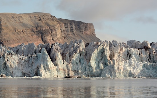 a large glacier with a mountain in the background