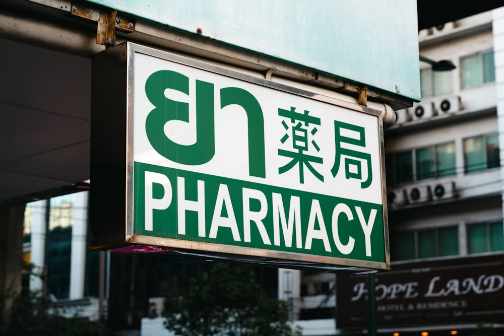 a pharmacy sign hanging from the side of a building