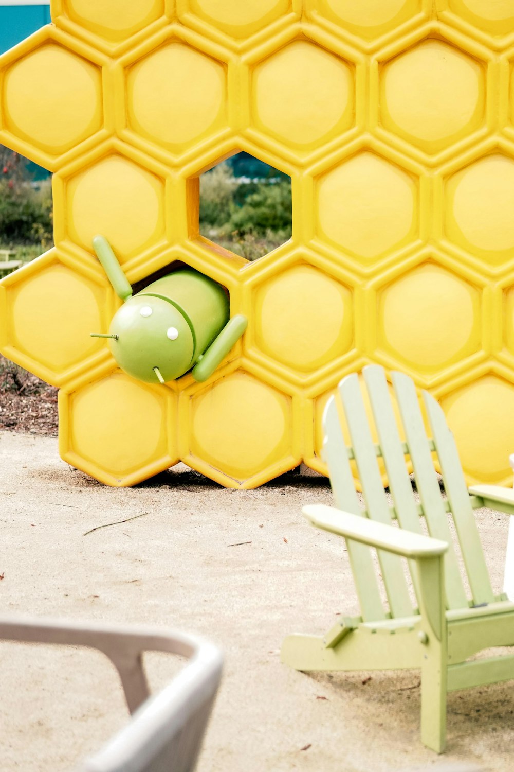 a yellow and green chair sitting next to a yellow wall