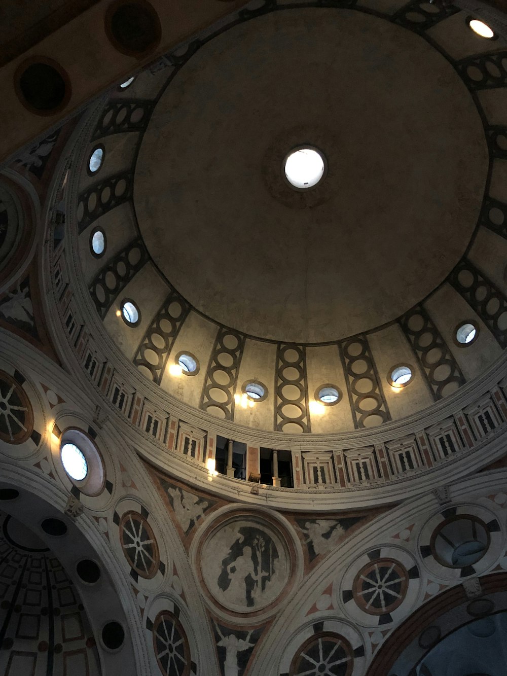 the ceiling of a large building with round windows
