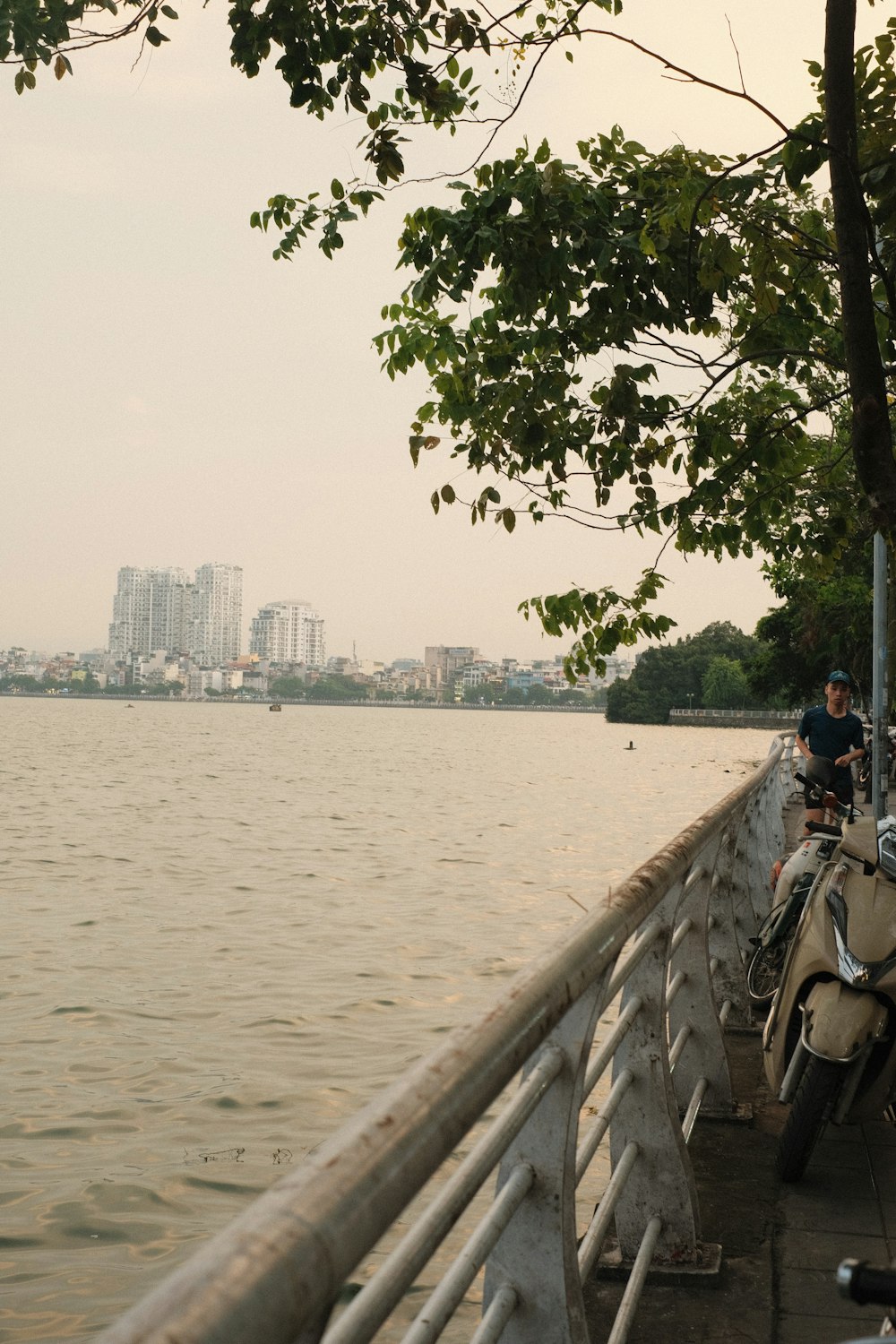 a motorcycle parked on the side of a road next to a lake