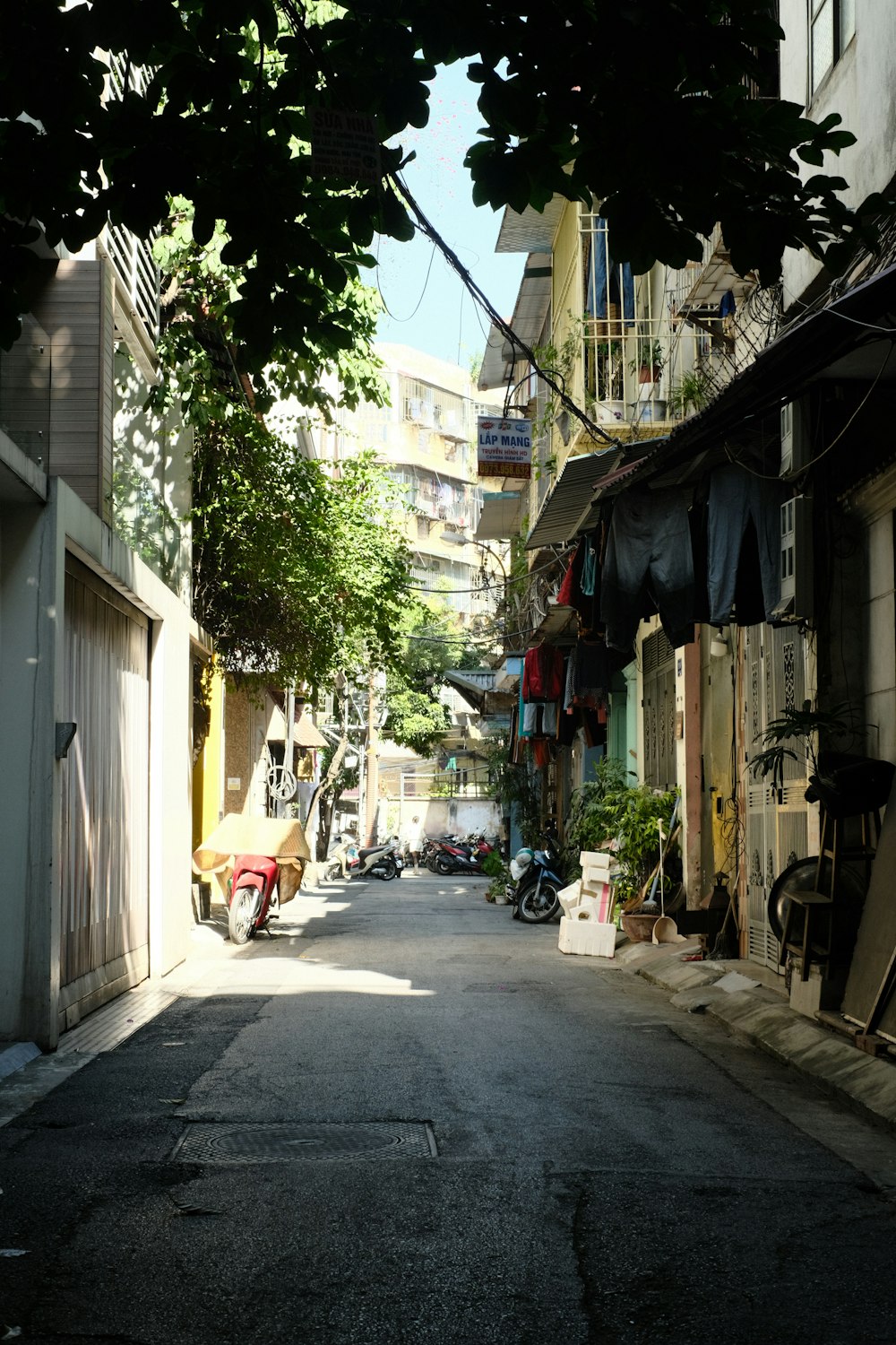 a narrow city street lined with parked motorcycles