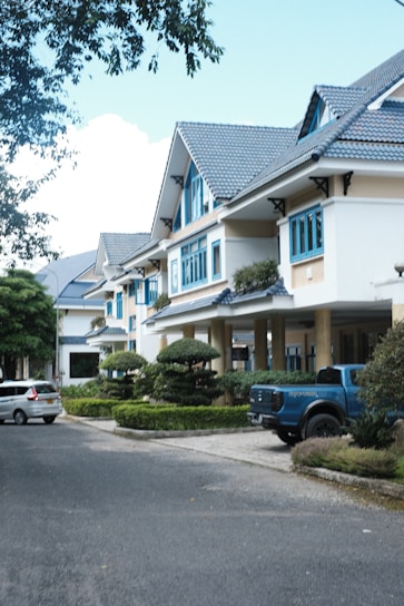 a blue truck is parked in front of a row of houses