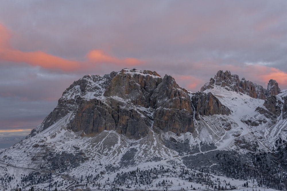 a snow covered mountain range under a cloudy sky