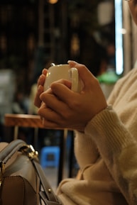a woman holding a coffee cup in her hand