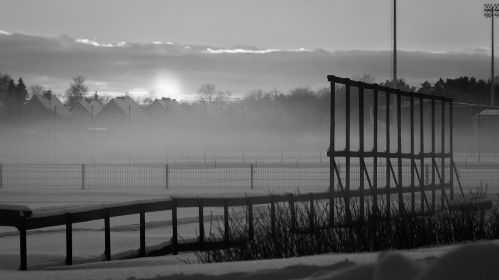 a black and white photo of a bench in the snow