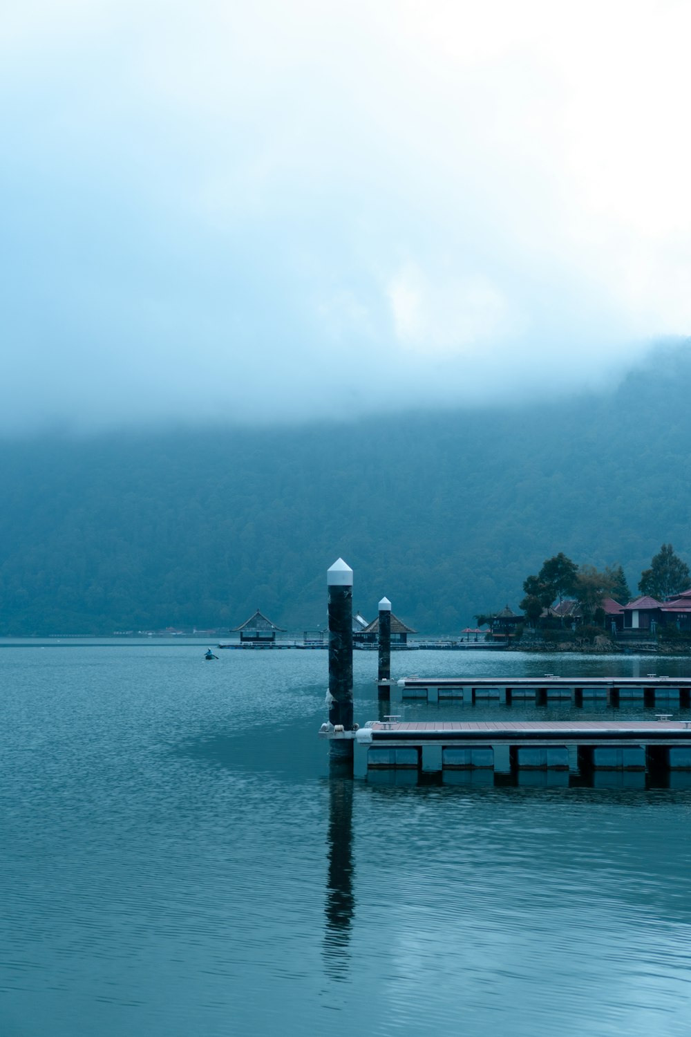 a dock in the middle of a lake with mountains in the background