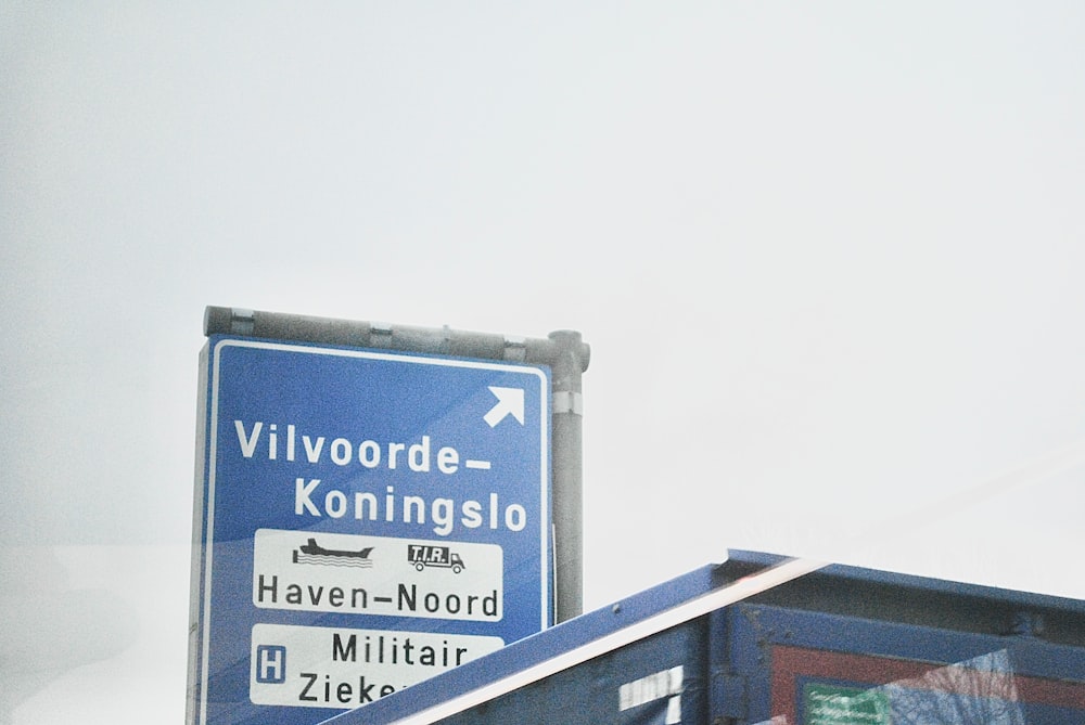 a blue street sign sitting on the side of a road