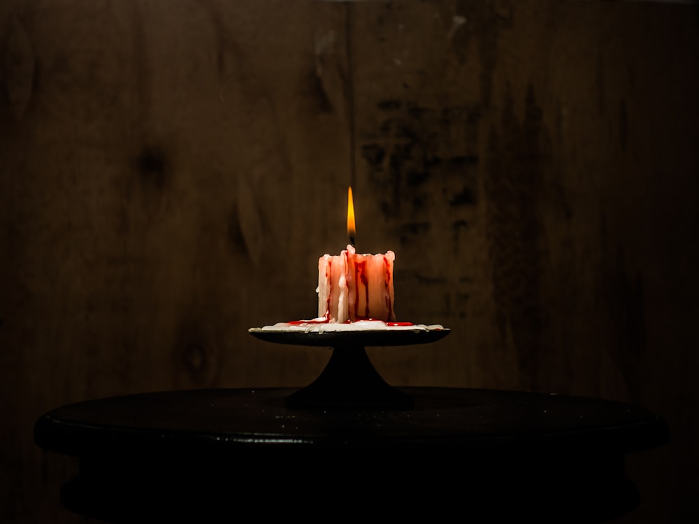 una candela accesa seduta sopra un tavolo