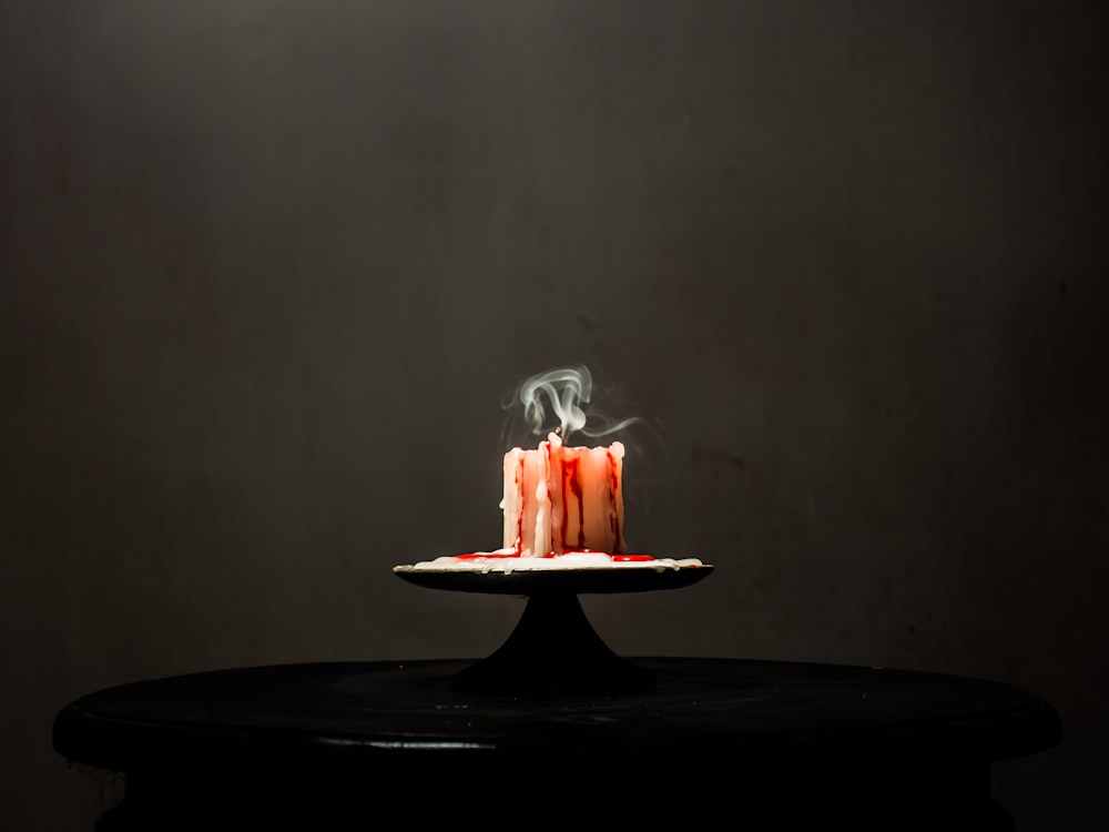 un pastel con una vela encendida encima