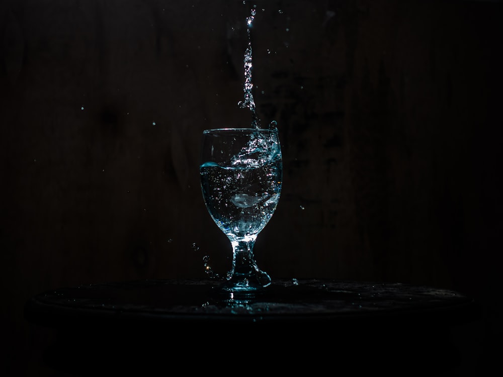 un verre rempli d’eau sur le dessus d’une table