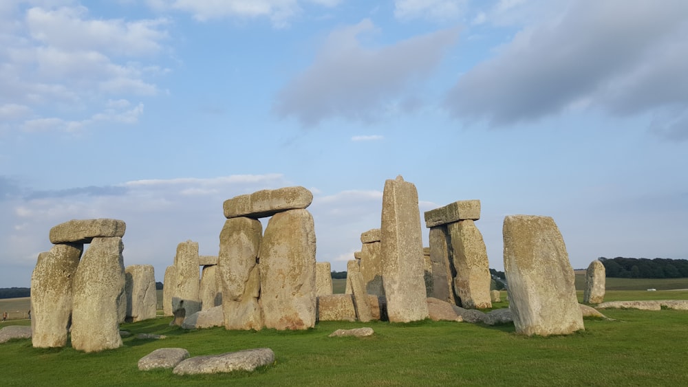 a group of large rocks sitting on top of a lush green field