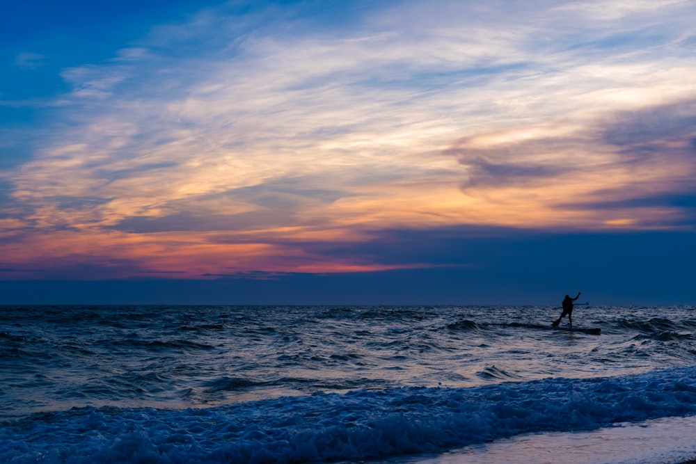 a person standing on a surfboard in the ocean