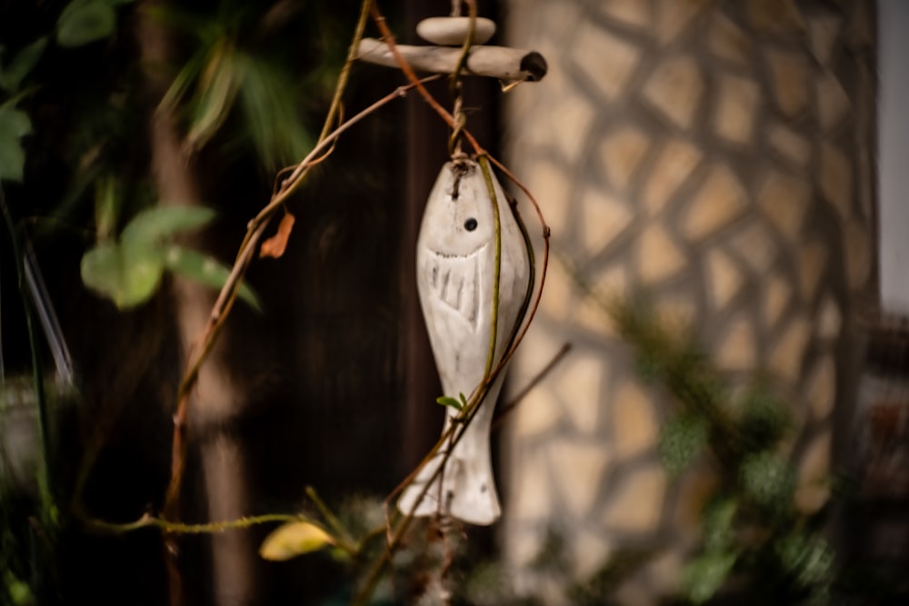 a white owl ornament hanging from a tree branch