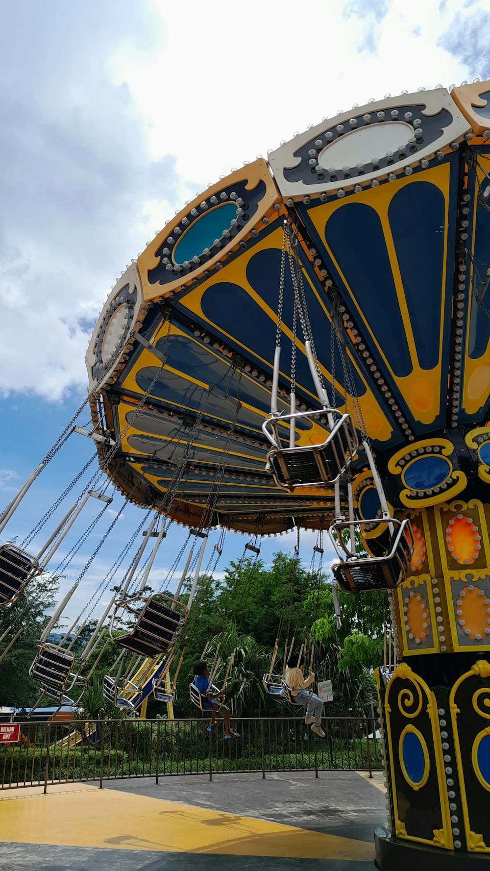 a yellow and blue carnival ride in a park