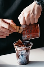 a person pouring chocolate into a cup