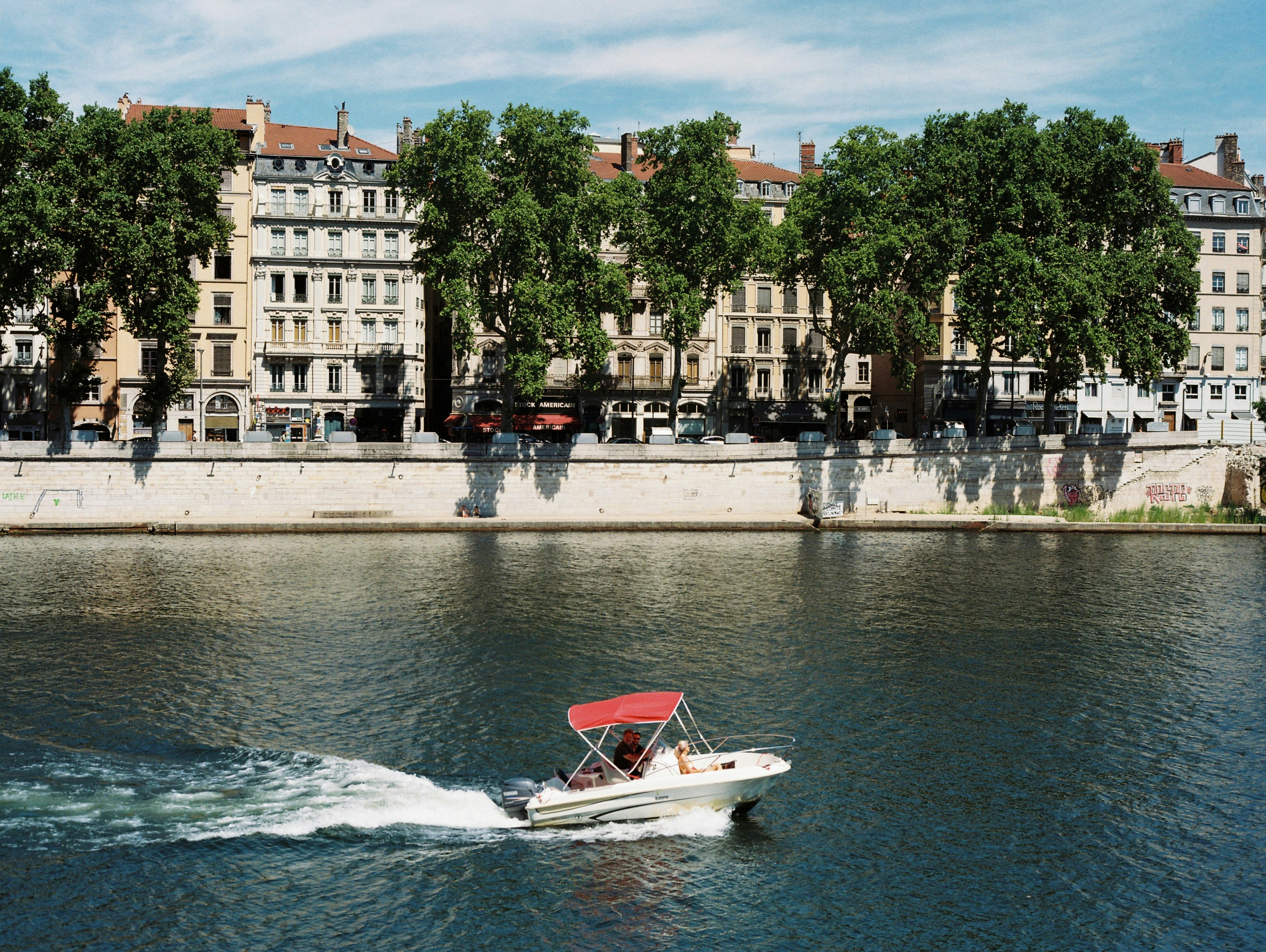 a boat traveling down a river next to tall buildings